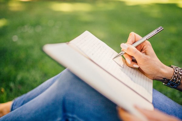 Nuori nainen kirjoittaa puistossa